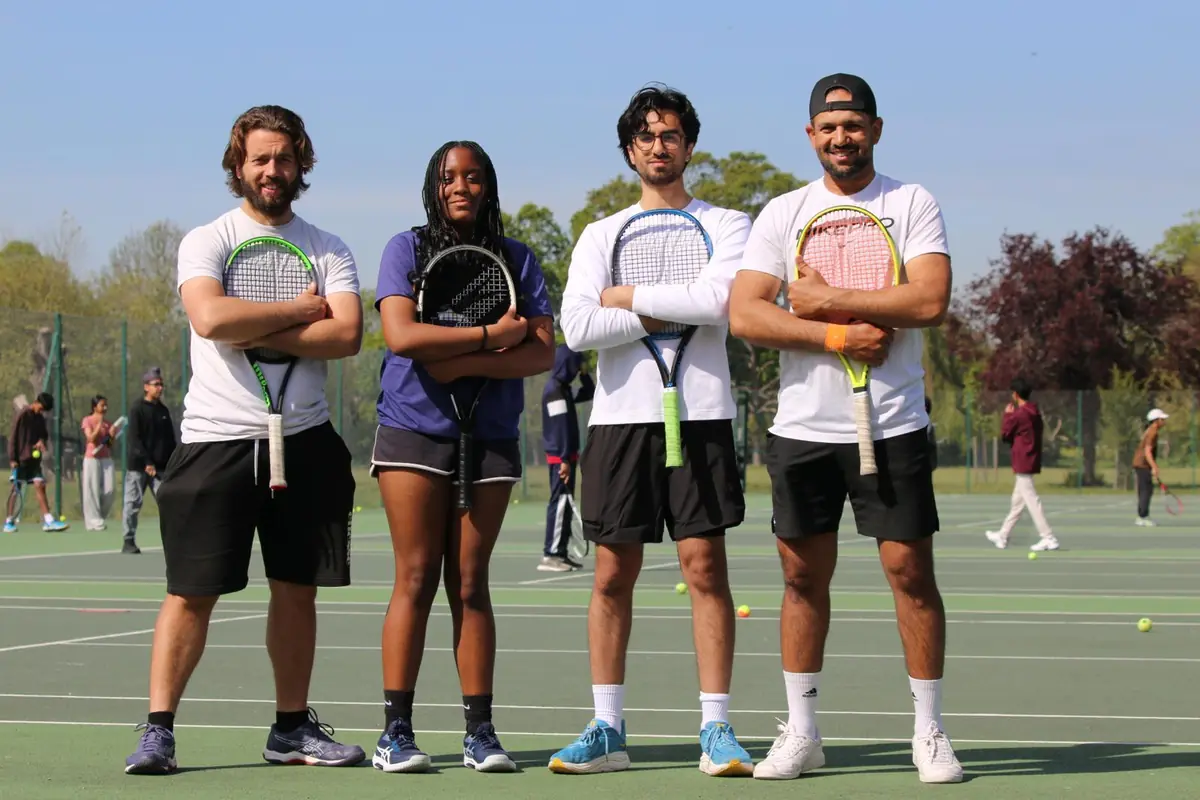 The Get Smart Tennis coaching team standing on court with their racquets